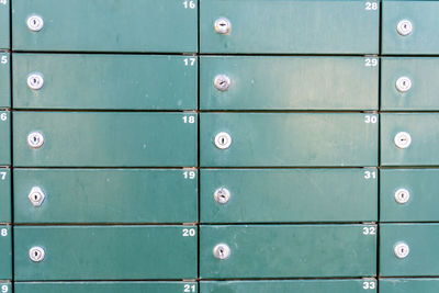 Close-up of some green metallic mailboxes.