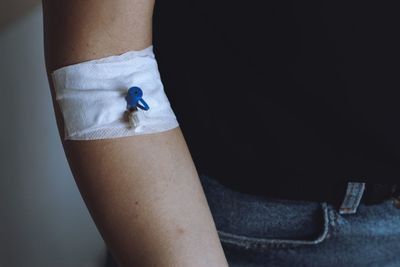 Midsection of woman with bandage on hand