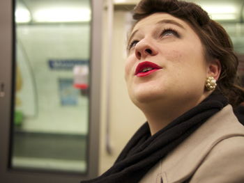 Close-up of woman looking up while sitting in train