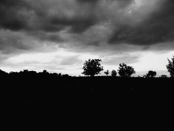 Silhouette landscape against cloudy sky