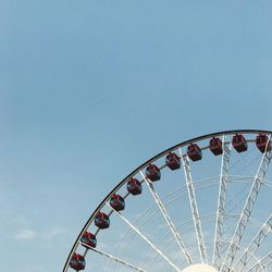 Low angle view of ferris wheel against clear blue sky