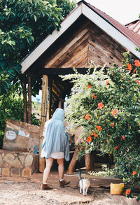 Rear view of women standing outside house