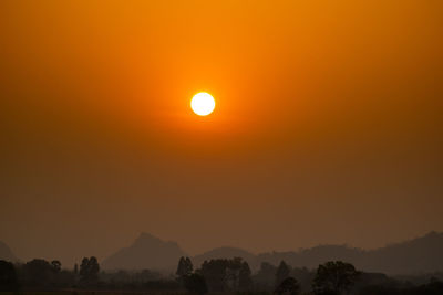 Scenic view of silhouette mountains against orange sky