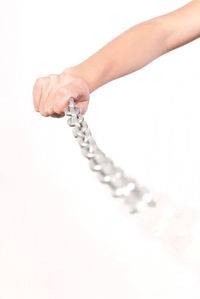 Close-up of hand holding paper over white background