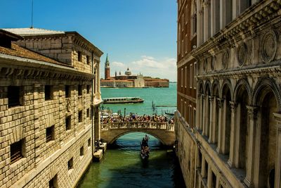 High angle view of gondola in canal amidst buildings on sunny day