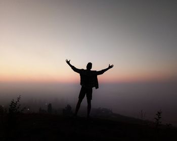 Silhouette man standing against clear sky during sunset