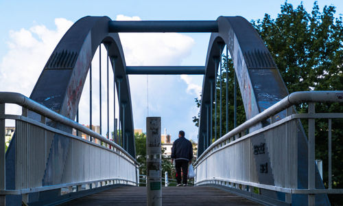 Rear view of people walking on bridge