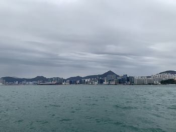 Scenic view of sea by buildings against sky