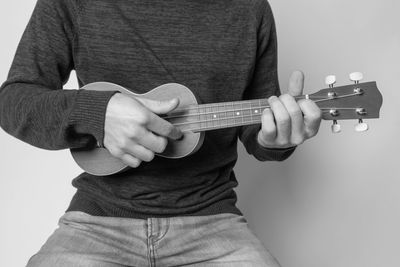Midsection of man playing guitar
