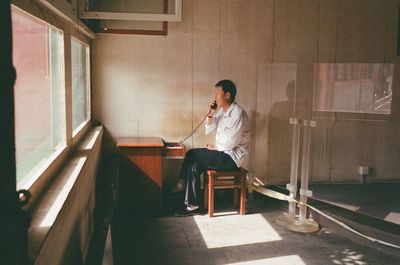 Full length of man sitting on chair