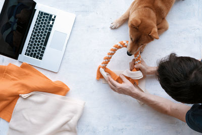 Adult man making diy homemade educational toys for dogs using a tutorial from the internet