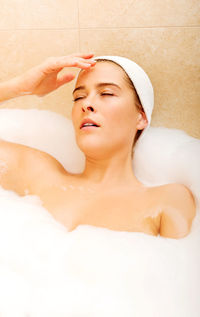 Woman bathing in bathtub at bathroom