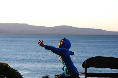 Woman in sea against clear sky