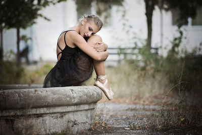 Side view of woman sitting outdoors