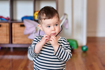 Cute baby boy is playing with toy glasses