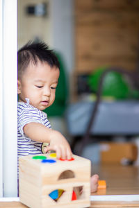 Cute boy playing with toy on floor