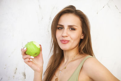 Portrait of young woman holding apple