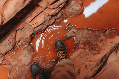 Low section of man standing on rock