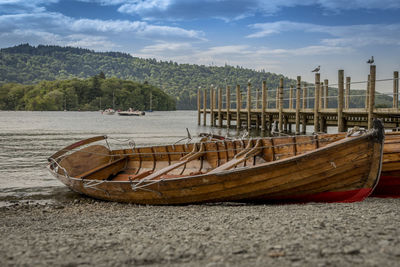 Boats moored on beach against sky