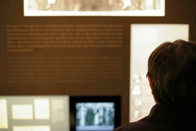 Rear view of man against information board