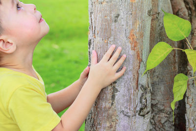 Close-up of girl playing on tree trunk
