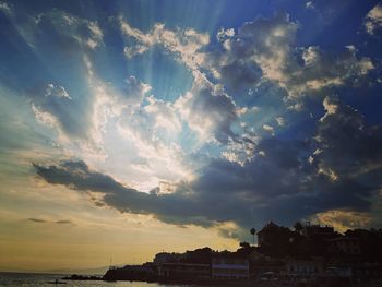 Panoramic view of buildings and sea against sky at sunset