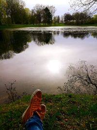 Low section of person on lake by plants