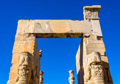 Low angle view of old ruins against blue sky