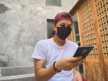 Full length of young man using mobile phone