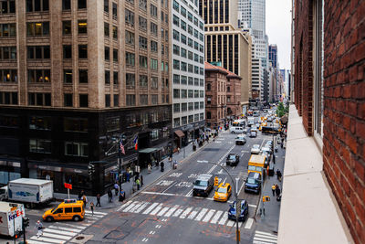 Vehicles on road amidst buildings in city