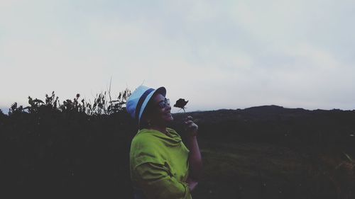 Midsection of woman standing against sky