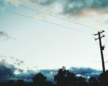 Silhouette of trees against cloudy sky