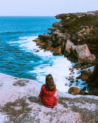 Rear view of people looking at sea against sky