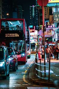 Cars on illuminated city street at night