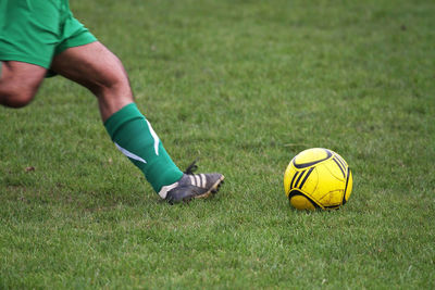 Low section of man playing soccer on field