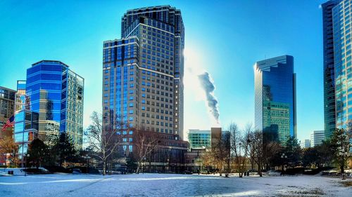 Modern buildings in city against blue sky