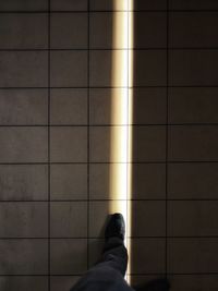 Low section of person on tiled floor