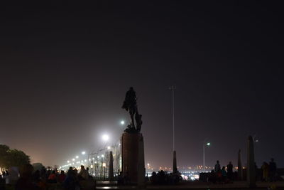 Statue in city at night