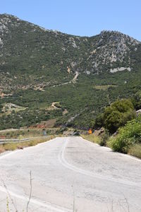 Road by mountain against sky