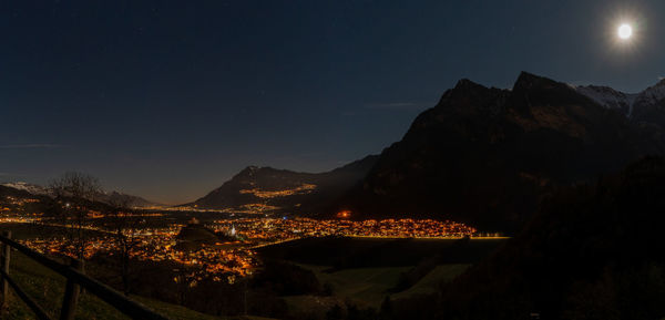Illuminated city against sky at night