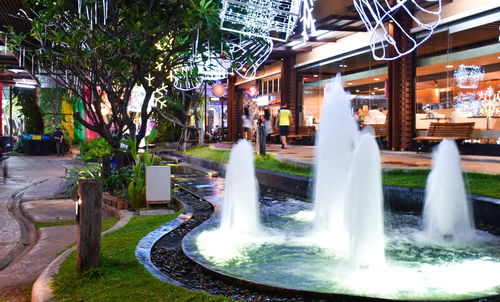 Fountain in park by buildings in city