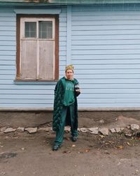 Full length portrait of boy standing against wall