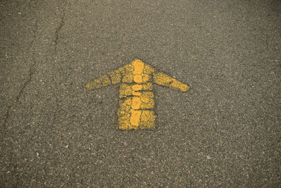 High angle view of yellow arrow sign on road