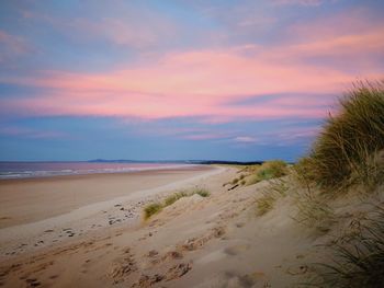 View of beach against cloudy sky