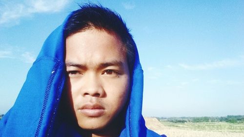 Close-up portrait of boy against blue sky