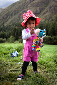 Full length portrait of a smiling girl holding plant