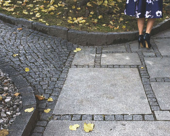 Low section of woman walking on sidewalk