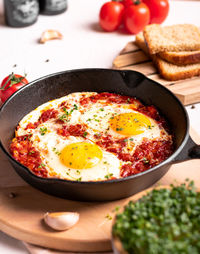 Traditional israel food eggs with tomatoes shakshouka in a pan close up