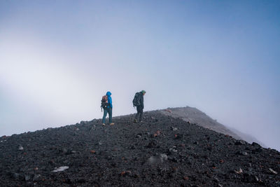 Male hikers hiking on mountain during winter