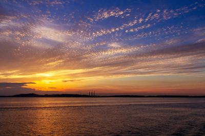 Scenic view of sea against dramatic sky during sunset